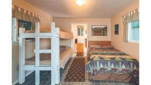 a bedroom with two beds and a bunk bed at Cabin 3 Lynn View Lodge in Haines
