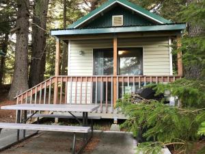 a tiny house in the woods with a bench at Cabin 3 Lynn View Lodge in Haines