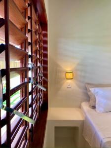 a room with a bed and a light on a wall at Casa Surya in São Miguel do Gostoso