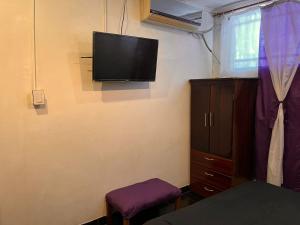 Habitación con TV de pantalla plana en la pared en CHE LOLITA HOUSE en Buenos Aires