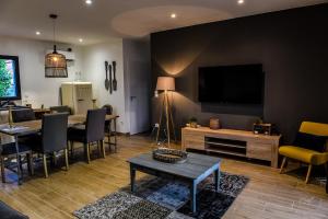 Secret de campagne Spa في Grisolles: غرفة معيشة فيها تلفزيون وطاولة وكراسي