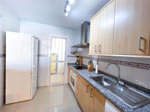 uma cozinha com um lavatório e um frigorífico em Apartamento acogedor de 2 dormitorios a solo 150 m de la playa Sabinillas, Manilva em San Luis de Sabinillas