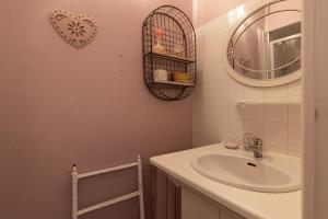 een badkamer met een wastafel en een spiegel bij Maisonnette La Chaleureuse in Jonzac