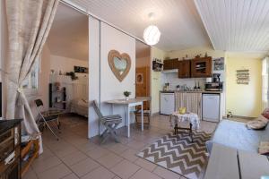 a kitchen and a living room with a table at Maisonnette La Chaleureuse in Jonzac