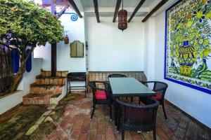 a patio with a table and chairs and a painting at Casa Perola -ocean view cottage in Carvoeiro +16 photos