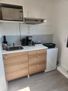 a small kitchen with a sink and a microwave at LOCATION T2 in Chenac-sur-Gironde