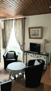 sala de estar con 2 sillas y TV en Maison Des Lys, en Jonzac