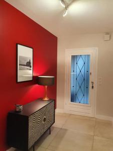 uma sala de estar com uma parede vermelha e uma porta em L'Abri Côtier, villa avec piscine au coeur des vignes em Caux