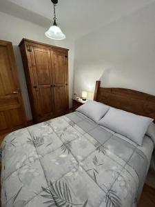 Un dormitorio con una cama grande con una manta. en El Desván de Gredos, en Navarredonda de Gredos