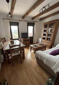 ein Schlafzimmer mit einem Bett und einem Tisch sowie ein Esszimmer in der Unterkunft El Desván de Gredos in Navarredonda de Gredos