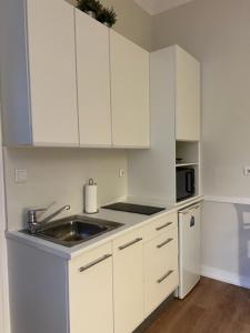 a white kitchen with white cabinets and a sink at Romantic & Renewed 1 bedroom Apartment in Campolide - 67 1E in Lisbon