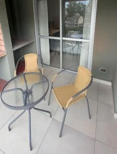 dos sillas y una mesa y una mesa y sillas en Apart New Green en Salta