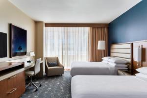 a hotel room with two beds and a desk at Marriott Marquis Houston in Houston