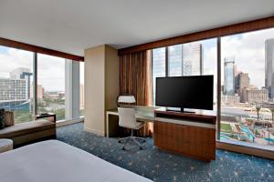 a hotel room with a bed and a desk with a television at Marriott Marquis Houston in Houston