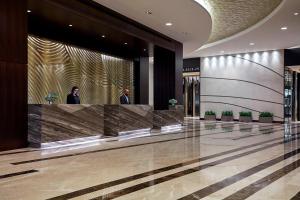 a lobby with two men standing at a reception desk at Marriott Marquis Houston in Houston
