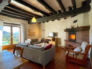 a living room with a couch and a fireplace at Casa Rural Erreteneko borda in Vera de Bidasoa