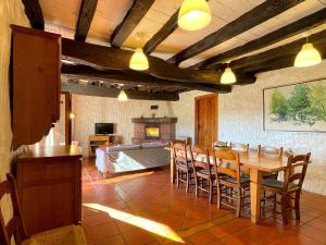 a dining room with a table and chairs and a fireplace at Casa Rural Erreteneko borda in Vera de Bidasoa