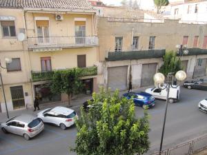 eine Gruppe von Autos, die auf einer Straße mit Gebäuden geparkt sind in der Unterkunft La Casa sul Corso in Leonforte