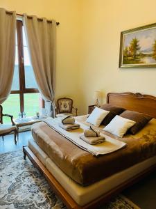 a bedroom with a large bed and a large window at Château de Crènille in Chaumes-en-Brie