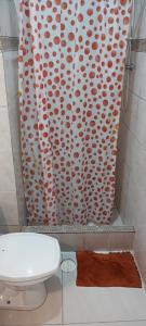 a bathroom with a toilet and a shower curtain at Morada BemTeVi Guest House in São José dos Campos