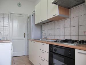 a kitchen with white cabinets and a black stove top oven at La Casa sul Corso in Leonforte