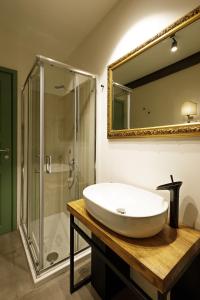 Palà Suites في نابولي: حمام مع حوض ودش ومرآة +175 صورة