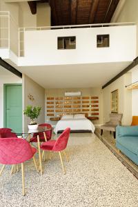 Palà Suites في نابولي: غرفة نوم بها سرير وطاولة وكراسي