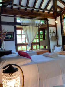 a bedroom with a large white bed with a window at Guest House Tânia Alves in Pratinha +114 photos