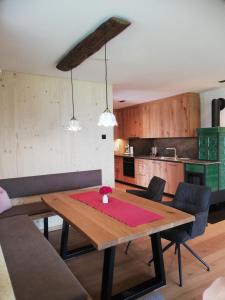 a dining room with a wooden table and a kitchen at Serner am See in Zell am Moos