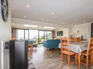 a kitchen and living room with a table and chairs at Cormorant in Holywell Bay