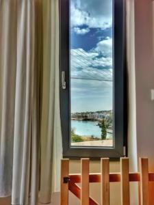una ventana con vistas al océano en Oinoni's Home - XANTHIPI apartment, en Souvala