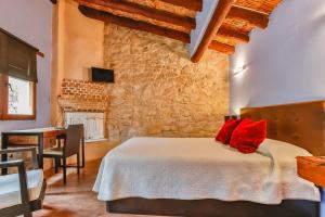 ein Schlafzimmer mit einem Bett mit roten Kissen darauf in der Unterkunft Fonda La Grancha in La Fresneda