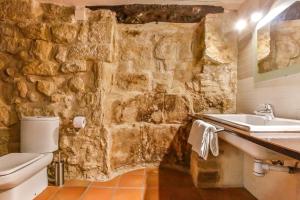 Baño de piedra con lavabo y aseo en Fonda La Grancha en La Fresneda