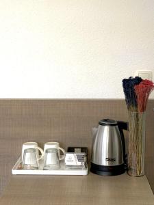 a shelf with a coffee maker and a tea kettle at Stone Bridge Hotel in Peje