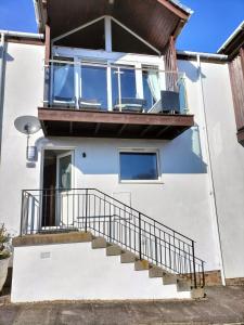 a house with a balcony with a staircase at Seaview cosy 2 bed home in Lamlash in Lamlash