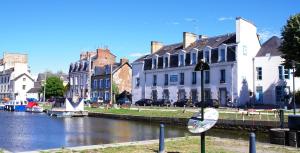 eine Stadt mit Gebäuden und einem Fluss mit Booten in der Unterkunft Auberge de Jeunesse HI Rennes in Rennes