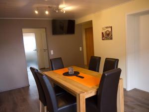 een eetkamer met een houten tafel en zwarte stoelen bij Ferienwohnung Bing in Rust