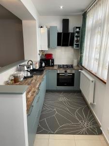 a kitchen with blue cabinets and a stove top oven at Apartment Victoria in Victoria