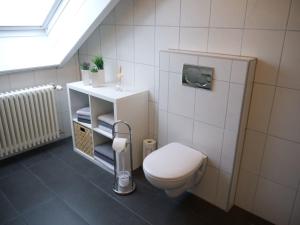 een badkamer met een wit toilet en een wastafel bij Ferienwohnung Bing in Rust