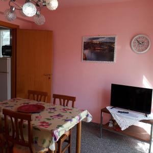 a dining room with a table and a television at Casa Rosette in Pozzallo