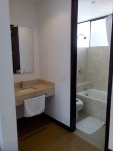 梅爾加的住宿－Suite Sumapaz Hotel，一间带水槽、浴缸和卫生间的浴室
