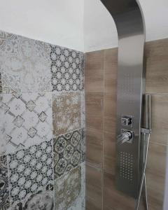 a bathroom with a shower with tiles on the wall at La Bolgora Guesthouse in Novara