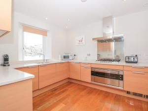 a kitchen with wooden cabinets and stainless steel appliances at 15 Dart Marina in Dartmouth