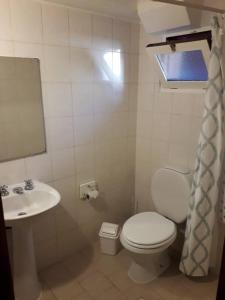 a bathroom with a toilet and a sink at Trabun in San Martín de los Andes +3 photos