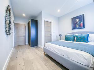 a bedroom with a large bed with blue pillows at Geneva House Apartments by Elegance Living in Peterborough