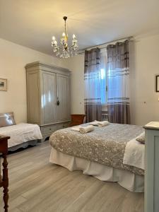 1 Schlafzimmer mit 2 Betten und einem Kronleuchter in der Unterkunft A casa Gasperini - Appartamento in centro a Casalecchio di Reno in Casalecchio di Reno