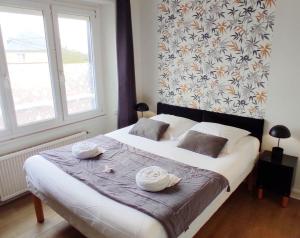 1 dormitorio con 1 cama grande y 2 toallas. en Auberge aux Marais en Montmartin-en-Graignes