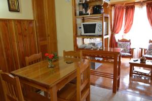 sala de estar con mesa de madera y TV en Lejana Patagonia en Esquel