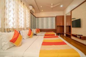 a hotel room with two beds and a flat screen tv at Uddhav Vilas A Family Hotel in Udaipur