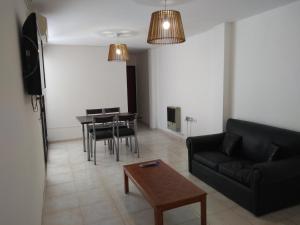 een woonkamer met een zwarte bank en een tafel bij Balcarce Suits PB in Bell Ville